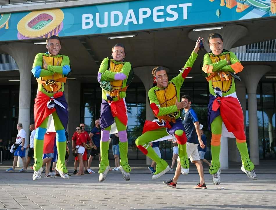 两位头发花白的老球迷并肩坐在看台上，岁月在他们脸上刻下了深深的痕迹，但眼中对足球的热爱依然炽烈，他们共同展开一条围巾，上面印着他们支持了一生的球队队徽