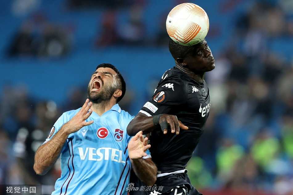 主教练在场边紧握双拳，向场内球员激动地呐喊指挥，神情专注且充满必胜的信念