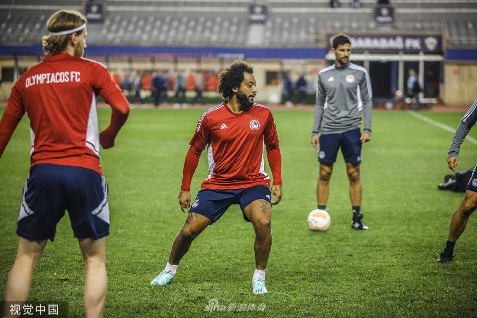 奥林匹亚科斯全队围成一圈进行战术部署，队员们聚精会神聆听，展现出紧密的团队凝聚力。