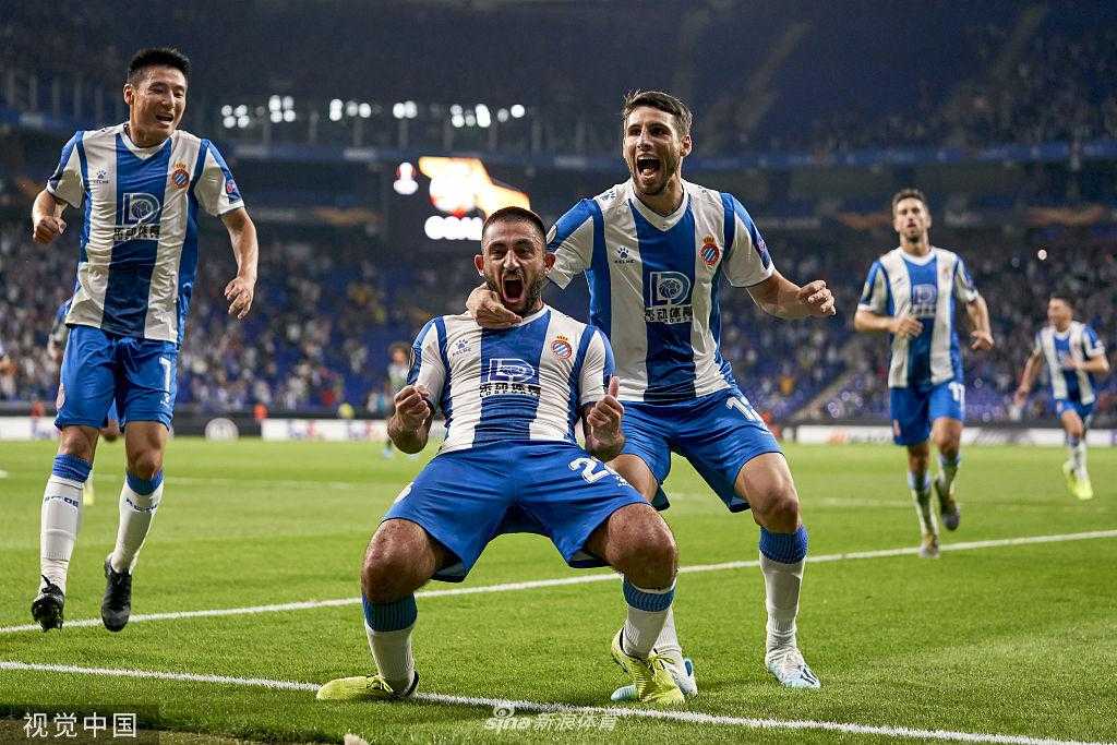 武磊与队友围在一起庆祝进球，他开心地笑着，是团队中不可或缺的一份子