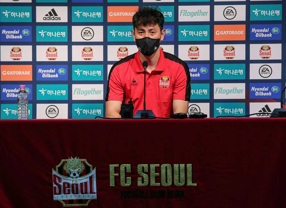 池东沅十年旅欧终归巢 首尔FC发布会尽显游子深情 在聚光灯下,池东沅眼神坚定地凝视前方,桌前的名牌和话筒标志着他以首尔FC球员身份的新起点,身后深蓝色的背景板如同等待他征服的新战场。