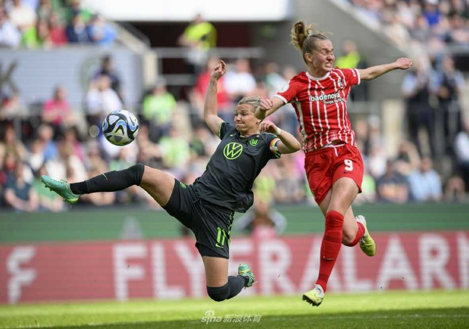 沃尔夫斯堡球员在角旗区与队友激情相拥庆祝进球，脸庞上写满了纯粹的快乐