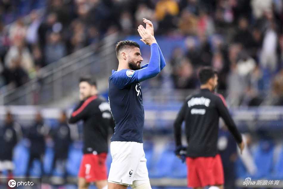 吉鲁张开双臂激情滑跪，他的身后是同样狂奔庆祝的队友，而远处的土耳其球员则无奈地低垂着头