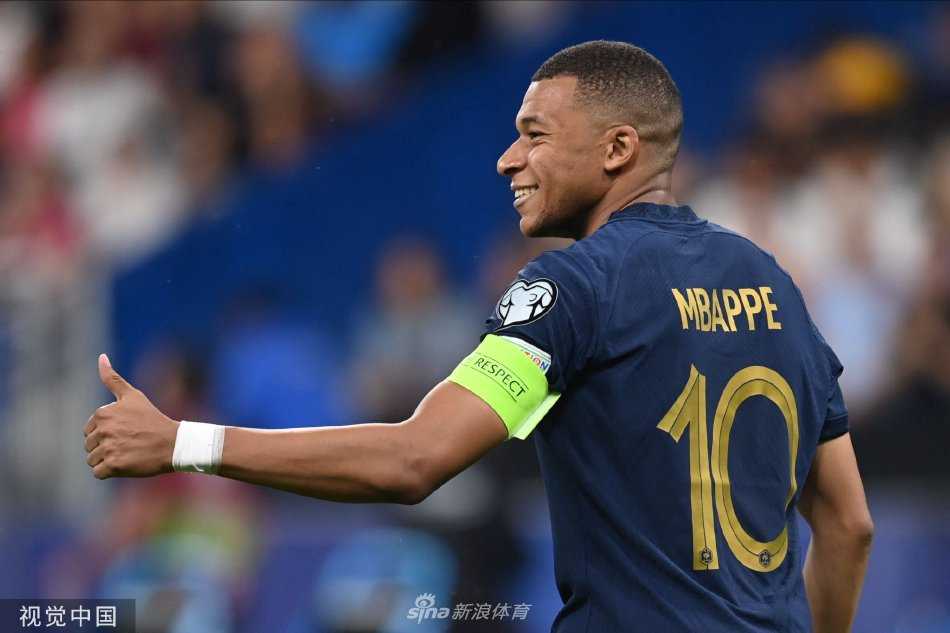 姆巴佩点球破网后张开双臂奔跑庆祝，身后是追逐欢呼的队友