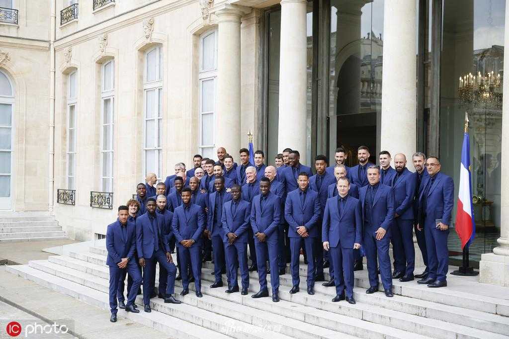 法国总统埃马纽埃尔·马克龙面带微笑，亲自为法国队队长雨果·洛里佩戴荣誉军团勋章，两人目光交汇，传递着感激与鼓励，定格这一荣耀时刻。