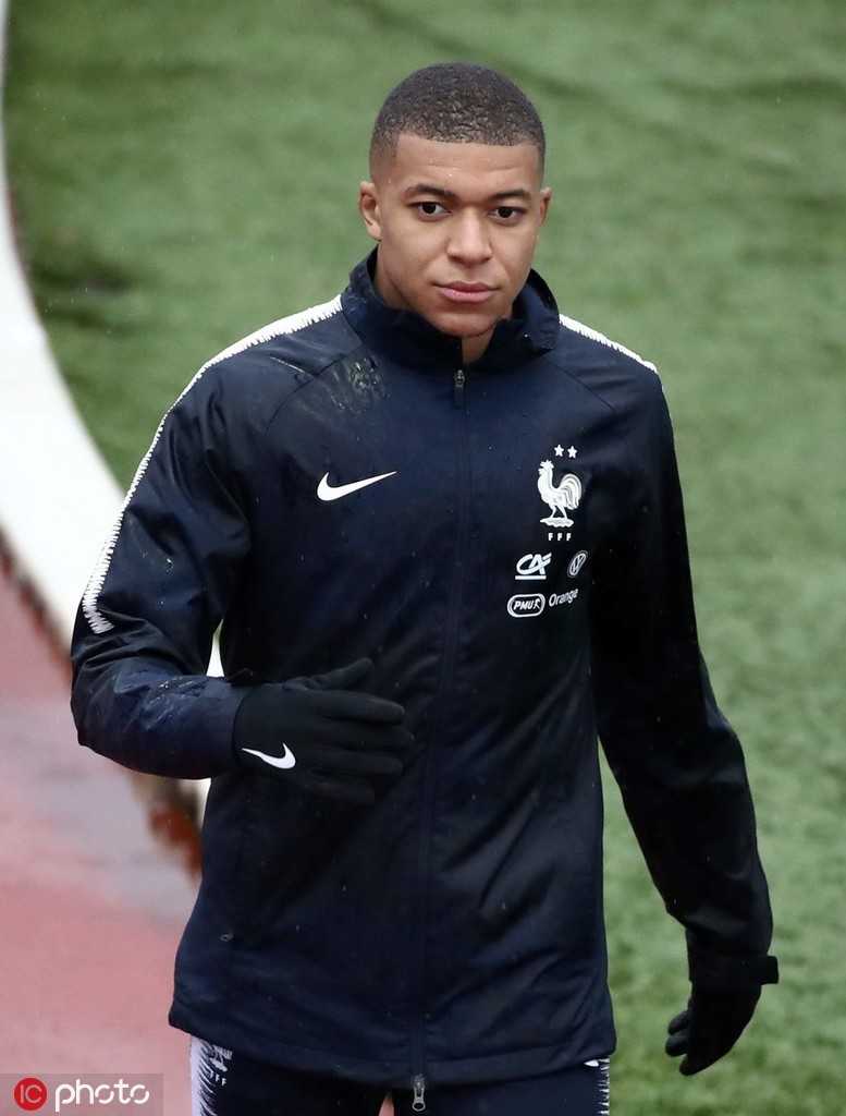 晨曦中的克莱枫丹训练基地，一名法国队球员独自加练，身旁是象征荣耀的雄鸡徽章