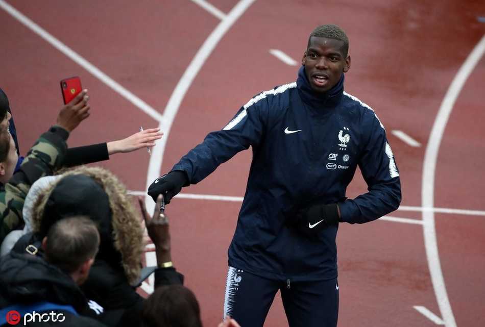 博格巴在训练间隙与队友姆巴佩说笑，背后是克莱枫丹基地茂密的橡树林