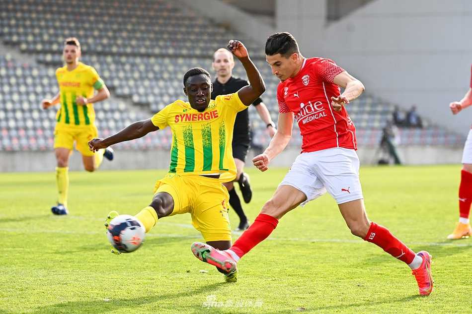 尼姆与南特球员在激烈拼抢中倒地瞬间，草屑飞溅，眼神充满对球权的渴望