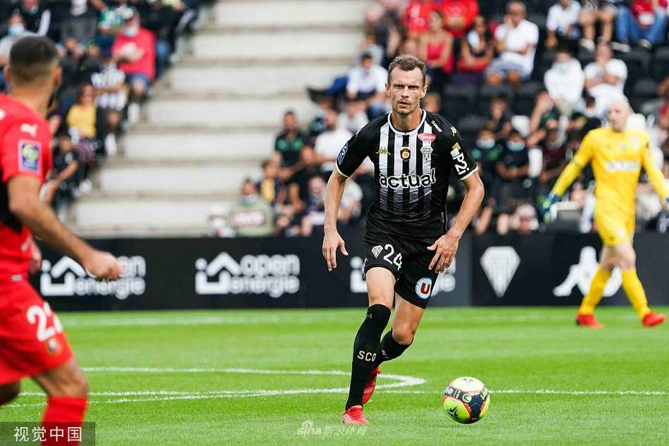 雷恩球员们围住主裁判激烈抗议判罚，队长挥舞着手臂神情激动，背景是昂热球员冷静地站在一旁，场边担架队随时待命