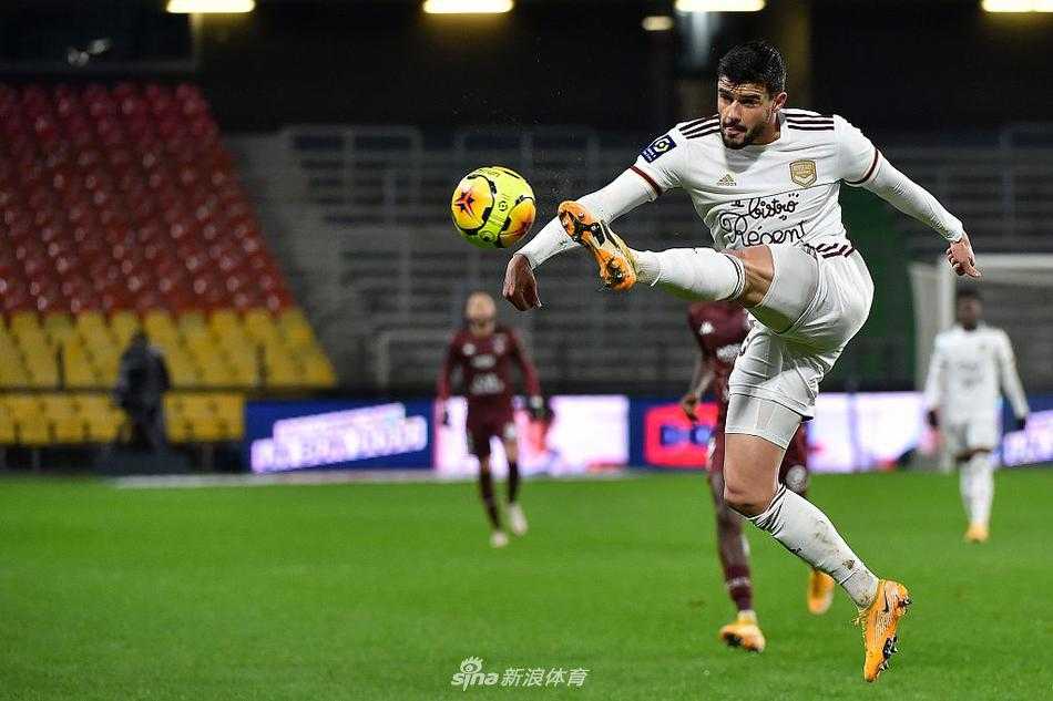 梅斯门将奥基贾在对方球员头顶高高跃起，双拳将皮球击出危险区域，他舒展的身体姿态和专注的眼神，完美诠释了门将守护球门的决心与勇气。