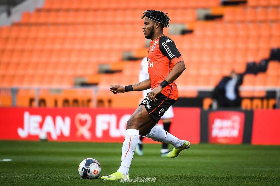 绿茵场上，两名洛里昂球员合力逼抢一名尼斯控球队员，一名防守球员从身后拉扯，另一名则从侧面试图卡住位置，双方球员的手臂缠在一起，比赛的激烈程度可见一斑。