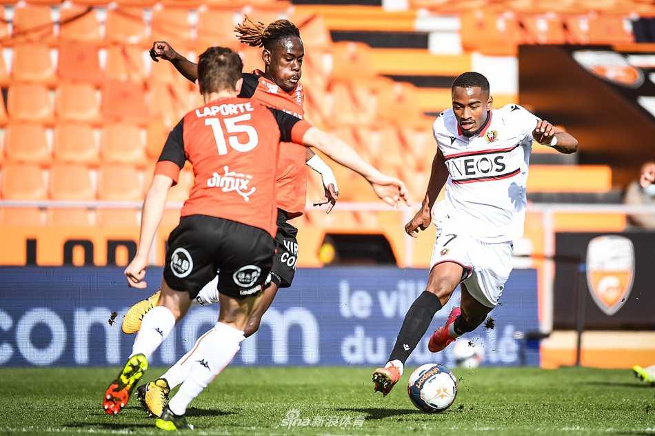 赛后，洛里昂的进球功臣维萨单手高举，向看台上的球迷致意，脸上带着坚毅而欣慰的表情。夜幕下的球场灯光将他照亮，背景中可以看出现场观众仍未离席，在为球员们的拼搏鼓掌。