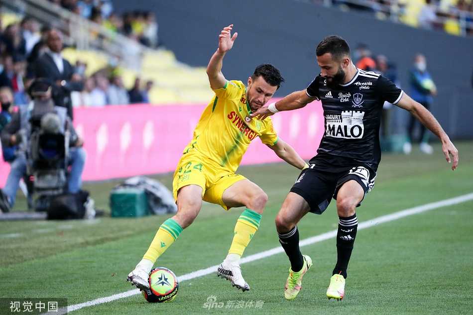 南特队门将阿尔邦·拉丰在比赛中高接低挡，他舒展身体奋力扑向来球，背景是紧张的比赛场面和对方球员期盼的眼神。