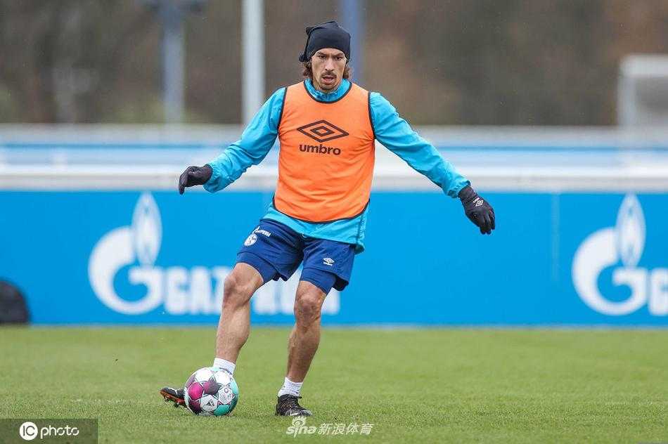 沙尔克04球员正在进行分组对抗，一名球员在队友的贴身逼抢下努力护住皮球，训练强度丝毫不减，尽管战绩不佳，但他们在训练场上的每一次拼抢都依然全力以赴