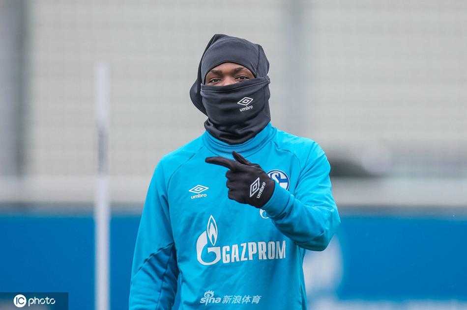 训练场上，沙尔克04的教练组成员正在给一名年轻球员进行单独指导，背景是空旷的看台，在球队最困难的时刻，经验传承与年轻力量的挖掘成为了他们唯一的希望