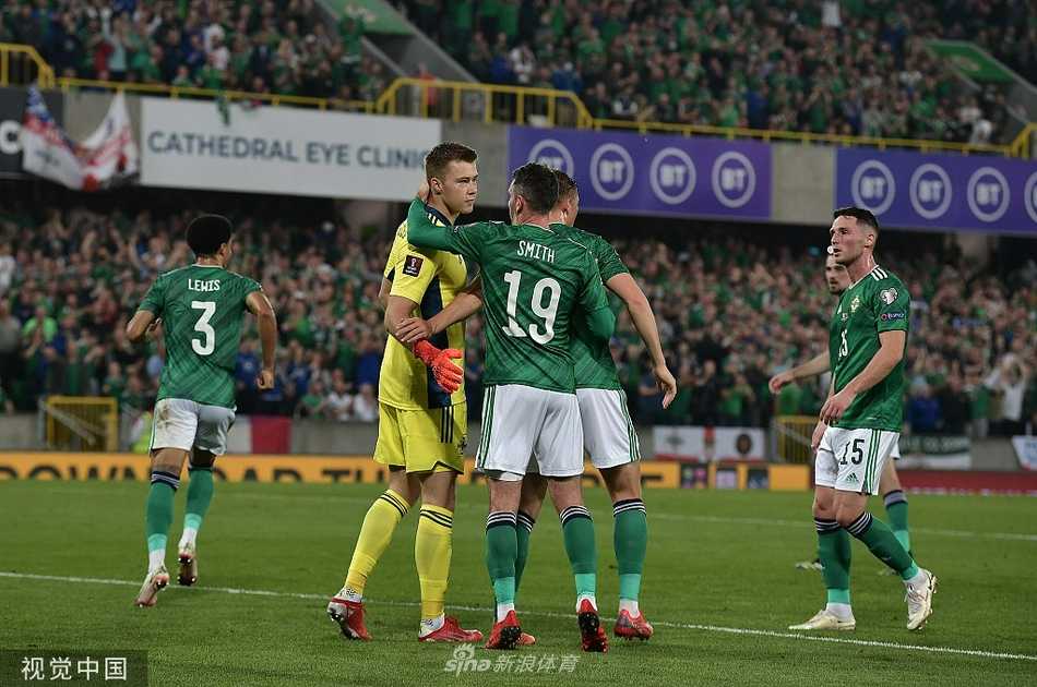 瑞士中场核心扎卡里亚在三人包夹下奋力护球，他肌肉紧绷，眼神坚毅，身边是北爱尔兰防守球员凶悍的逼抢，草屑飞溅，完美诠释了这场中场绞杀的激烈程度。