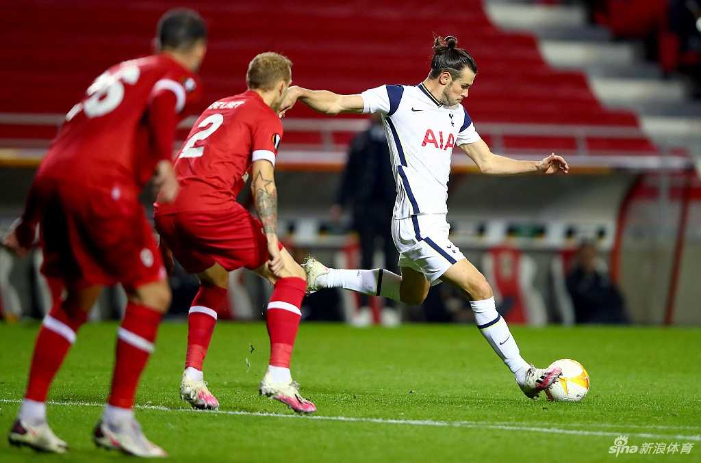 安特卫普球员拉斐尔洛夫进球后激情滑跪庆祝，身后的热刺门将洛里无奈地坐在地上，只能目睹皮球入网，这一瞬间定格了客队球员的失落与主队的狂喜。