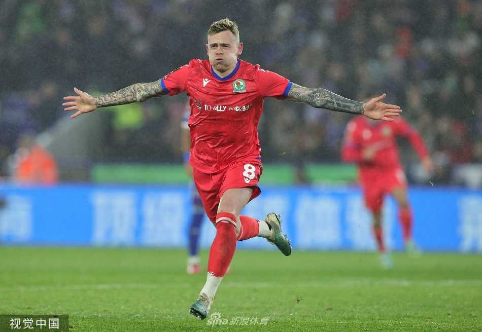 布莱克本球员多兰进球后张开双臂狂奔庆祝，身后是目瞪口呆的莱斯特城后卫