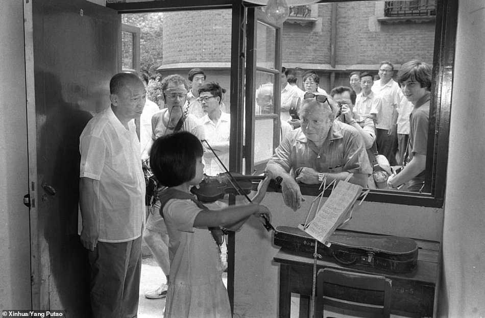 小提琴大师斯特恩在访华期间指导中国琴童，他眼神专注而亲切，琴童们则屏息凝神，仿佛在聆听来自另一个世界的乐音。