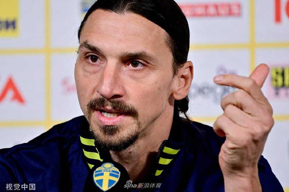 伊布在发布会桌前微微侧身，手指轻点桌面，正认真地回答记者的提问。