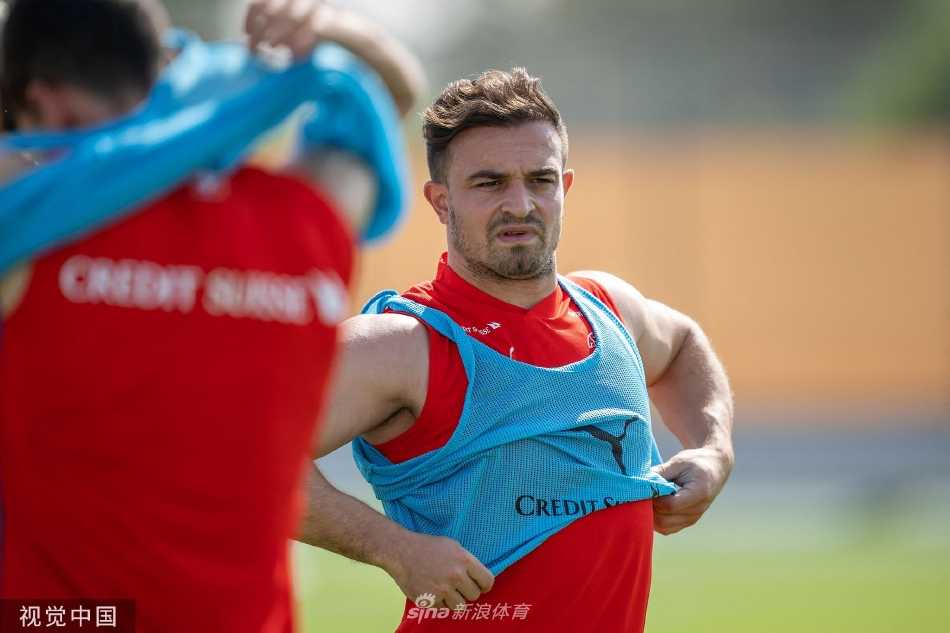 多哈训练场上，瑞士队球员们围成一圈专注聆听主帅雅金的战术部署，阳光下身影挺拔，战意盎然