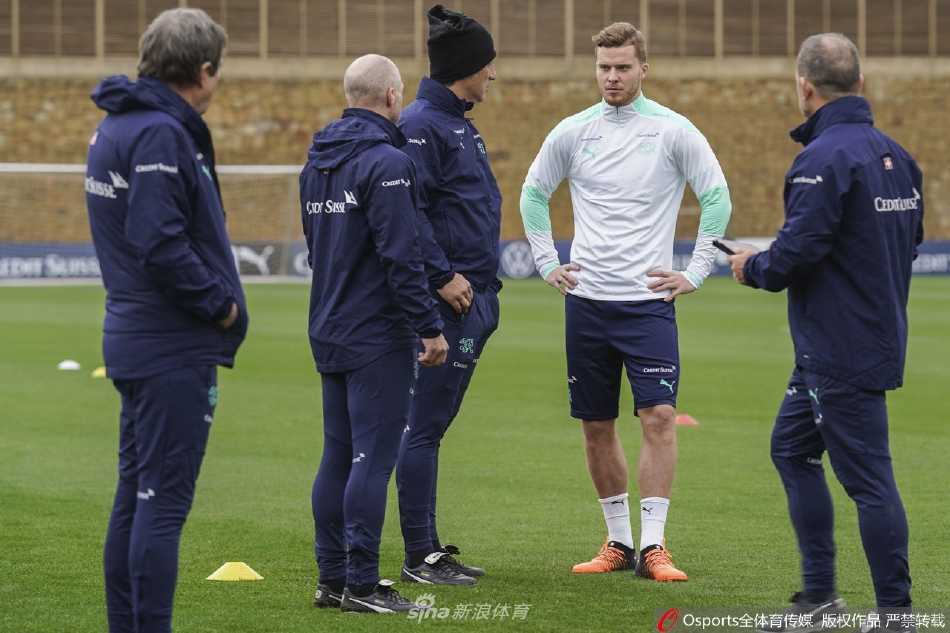 防守球员在对抗中高高跃起争抢头球，肌肉紧绷展现出力量与决心，筑起空中防线