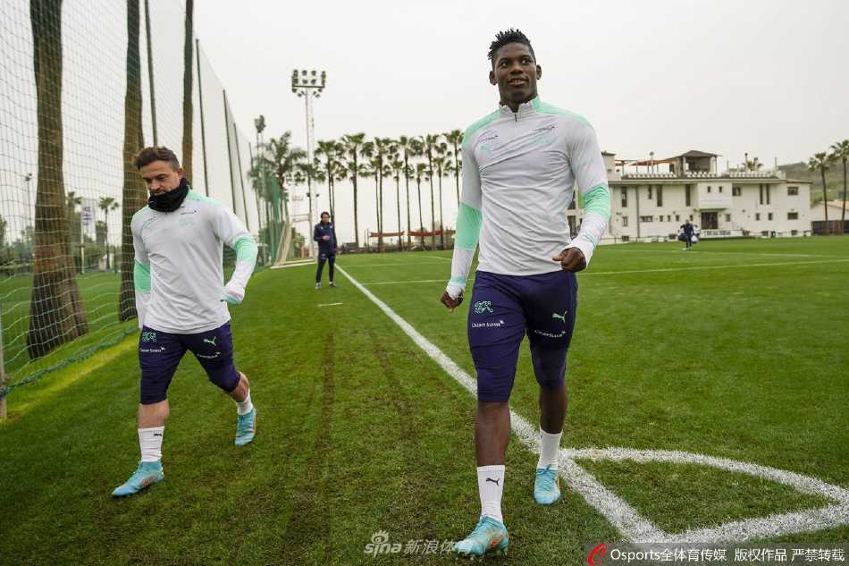 两名球员在轻松时刻相视而笑，紧张训练中流露的友谊与默契是团队战斗力的无形纽带