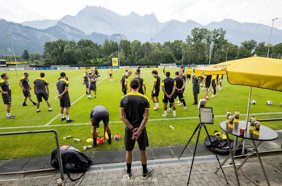 在瑞士阿尔卑斯山的怀抱中，多特蒙德的球员们正在进行热身，远处的山峦叠嶂与绿茵场构成了一幅天然的油画