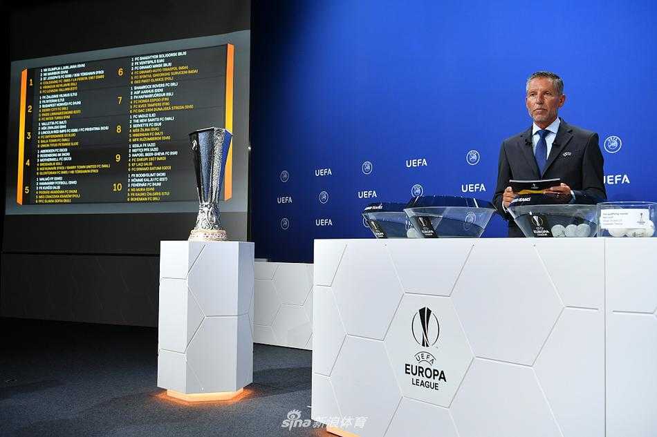 主持人与嘉宾确认抽签结果后，共同看向镜头，背后的显示屏正准备更新对阵图表