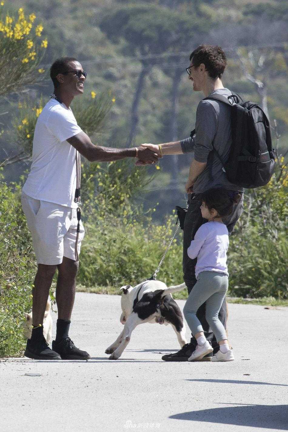 狗狗好奇地回头望向镜头，而它的主人尤斯廷·克鲁伊维特则专注地看着前方，一人一狗在西班牙的街头上演了一幅宁静和谐的画面