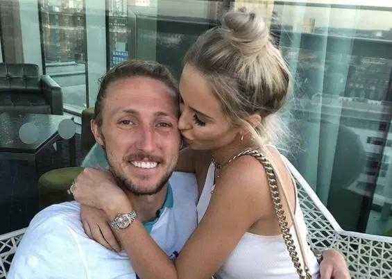 身着简约休闲装，她手中拿着一杯香槟，嘴角洋溢着自信的微笑，完美融入了赛后庆祝胜利的欢乐海洋。