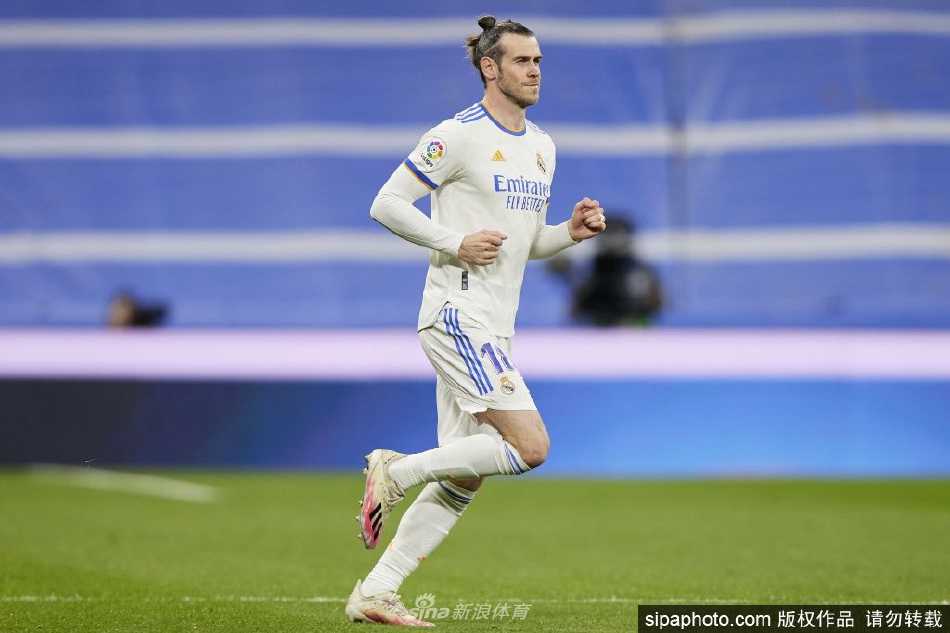 加雷斯·贝尔面带微笑，深情亲吻着欧冠冠军奖杯，眼中满是对荣耀岁月的珍视与告别时刻的复杂情感。