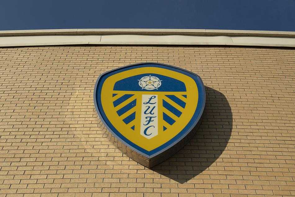 空无一人的东看台，黄蓝相间的座椅整齐排列，构成一幅壮观的几何图案。阳光透过顶棚的缝隙洒落，在座椅上形成斑驳的光影，仿佛在默默等待着下次爆满时球迷们雀跃的身影。