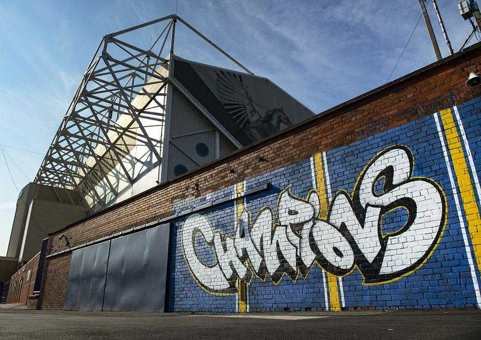 夕阳余晖温柔地洒在埃兰路球场的看台顶棚上，碧绿的草坪如同天鹅绒地毯般铺开，远处利兹市的天际线若隐若现，整个球场沉浸在一种庄严而神圣的静谧之中。