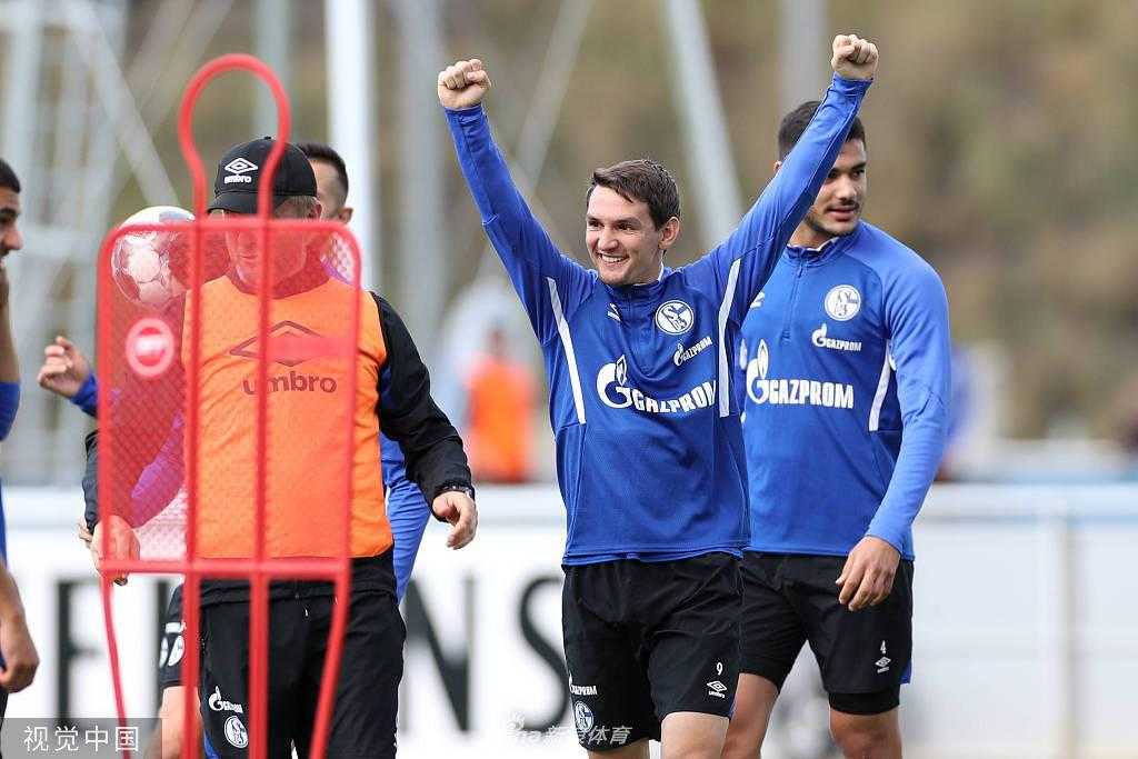 在教练组的注视下，一名沙尔克球员正全神贯注地进行带球绕杆练习，皮球仿佛粘在他的脚下，每一次触球都充满了节奏感。