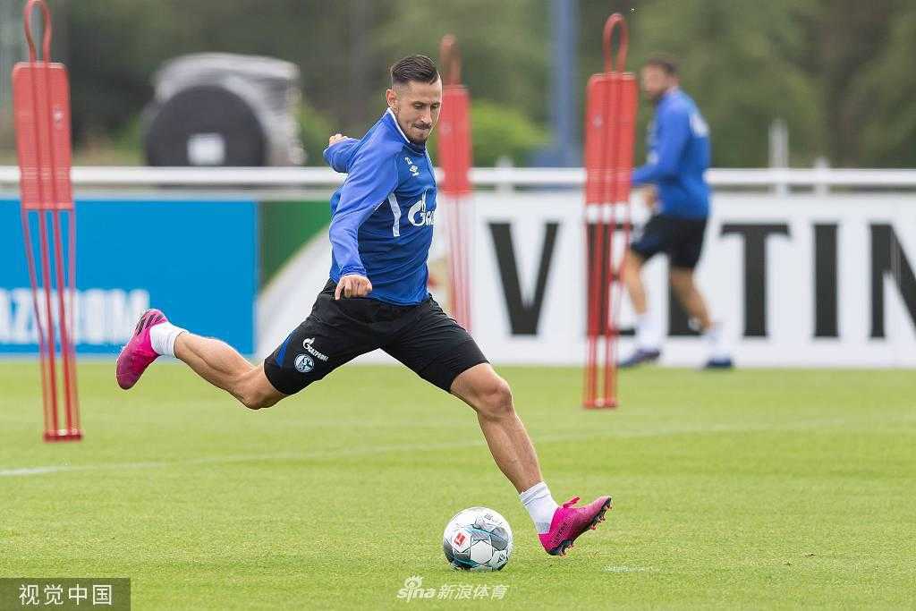 两名沙尔克04球员正在进行一对一的激烈拼抢，球衣被汗水浸透，眼神中充满对胜利的渴望，这是训练场上最真实的战斗缩影。