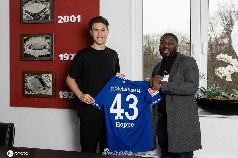 在费尔廷斯竞技场的背景前，年轻的马修·霍普身着沙尔克训练服，手持签字笔，在新合同上郑重落笔，神情专注而坚定，仿佛在书写自己的未来。