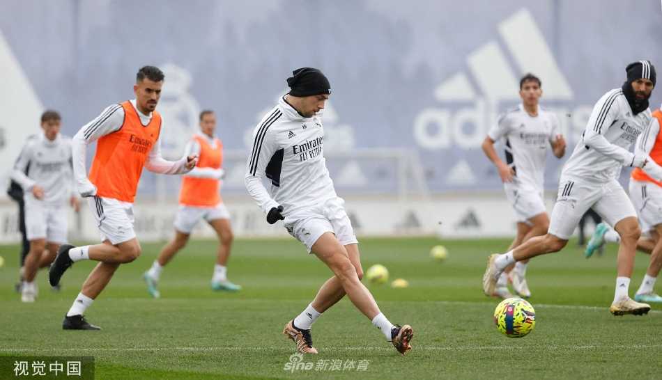 全景镜头下的皇马训练基地，绿草如茵，球员们分散在不同区域进行专项训练，井然有序。