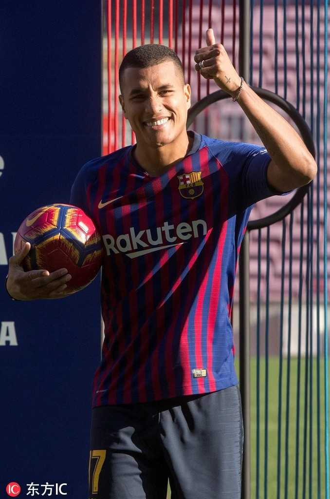 穆里略在巴萨俱乐部logo墙前的单人肖像，他穿着整洁的衬衫搭配巴萨运动外套，面带标志性的微笑。身后的巨大队徽象征着荣誉与责任，他的眼神中充满对未来的无限向往。