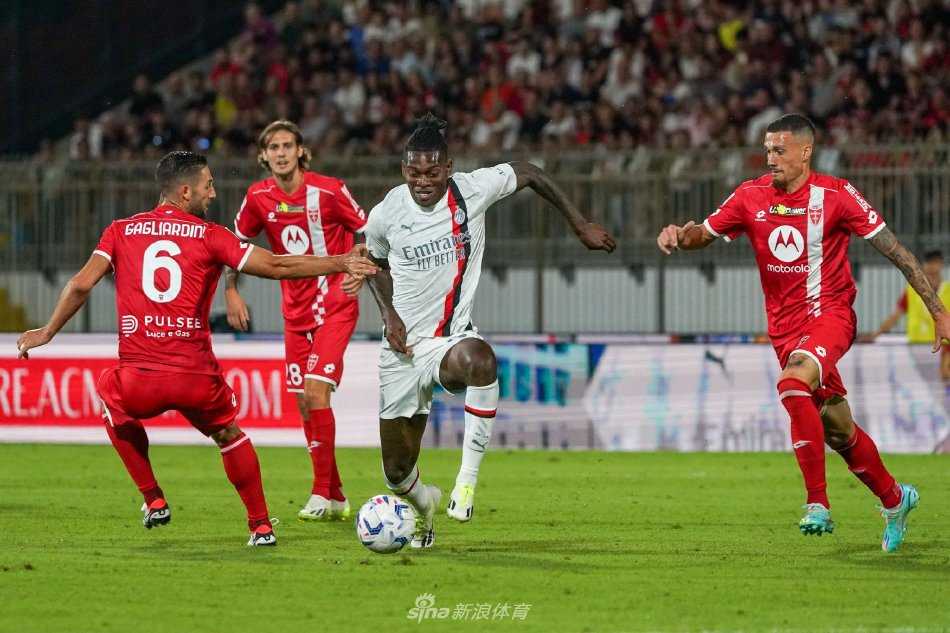 蒙扎队球员科尔帕尼在扳平比分后张开双臂激情庆祝，背景中AC米兰球员身影略显落寞