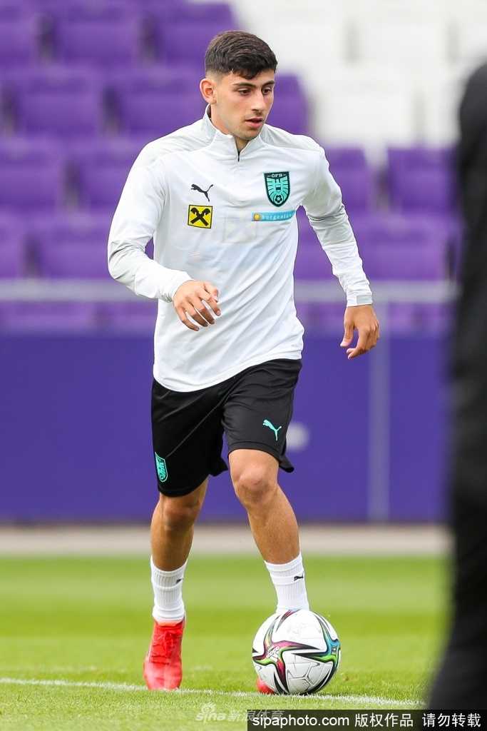 夕阳的余晖为训练场镀上金边，一名奥地利球员正在进行最后的射门加练，他专注地瞄准球门死角，足球划出的弧线仿佛承载着球队冲击世界杯的梦想。