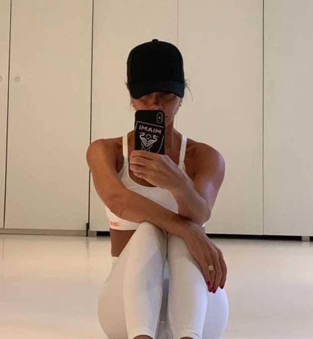 完成一组训练后，维多利亚对着镜子检查肌肉线条，眼神中透露出自信与满足。