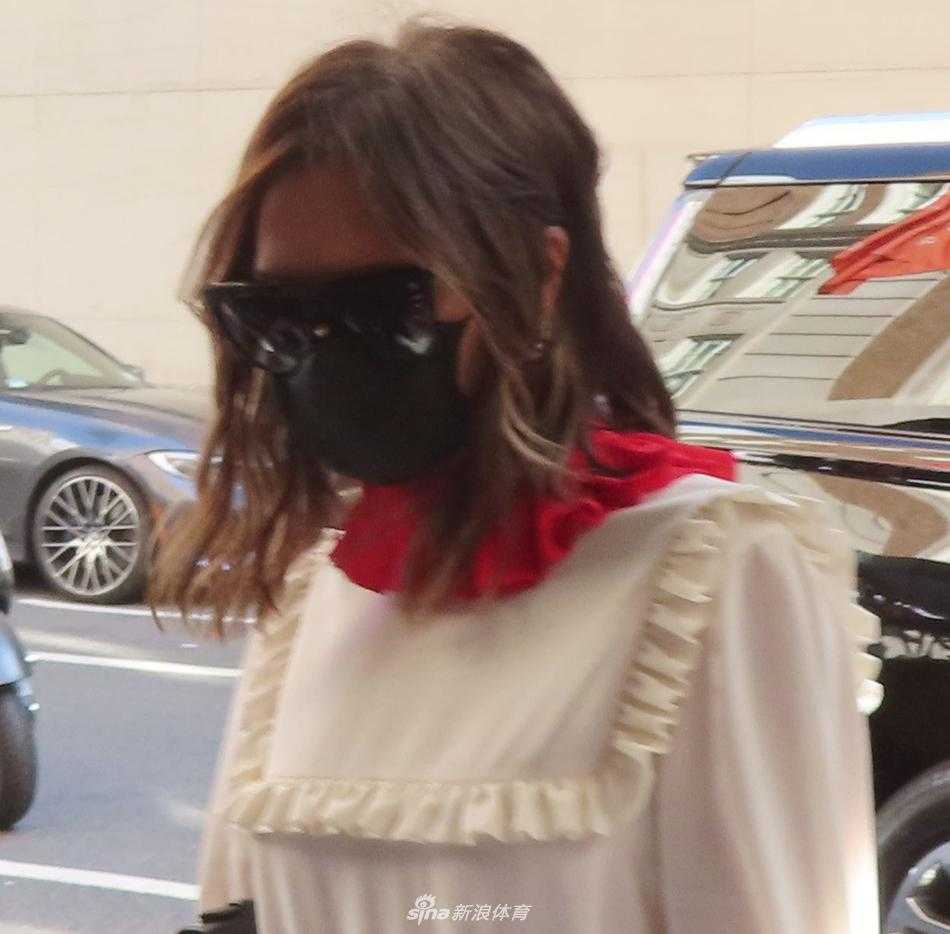 尽管戴着口罩，依然能感受到维多利亚精致妆容下的强大气场，她抬手轻抚秀发，眼神透过墨镜看向镜头，身后的纽约街景此刻都成了她的陪衬。