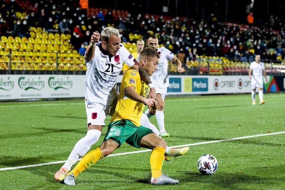 身穿蓝色球衣的阿尔巴尼亚进攻球员如猎豹般高速插上，却陷入了立陶宛白色防线的包围圈，一张张专注的面孔定格了瞬间的战术博弈。