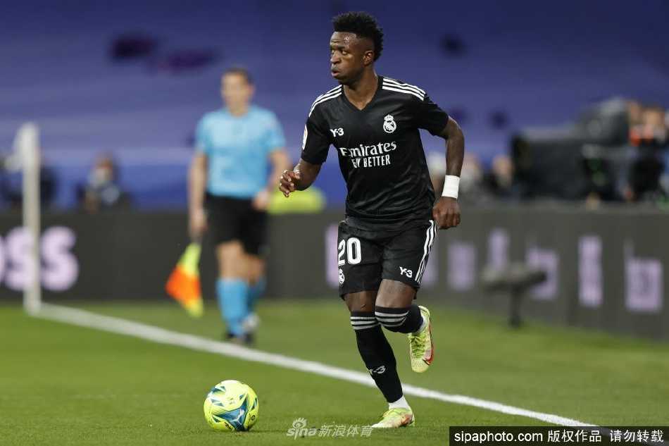 维尼修斯手持西班牙国籍文件，面向镜头露出标志性的开朗笑容，眼神中充满对未来的期待。