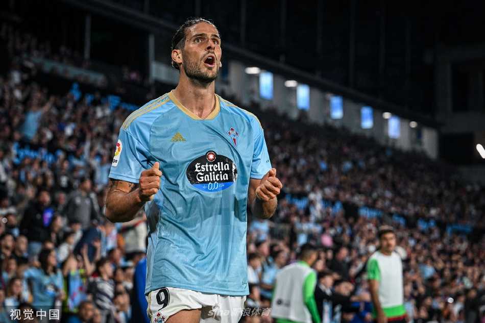 塞尔塔前锋在对方后卫贴身紧逼下艰难转身，试图在禁区前沿寻找起脚空间，表情专注而坚决。