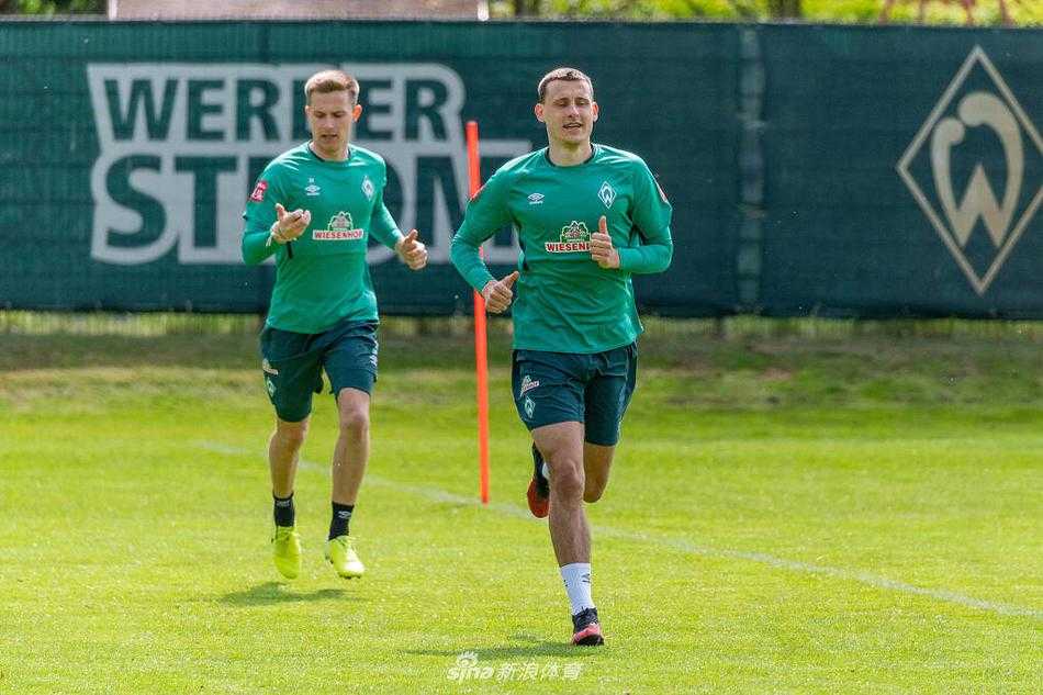 大迫勇也在空旷训练场上抬腿停球，眼神专注，身后是萧瑟的春日树林