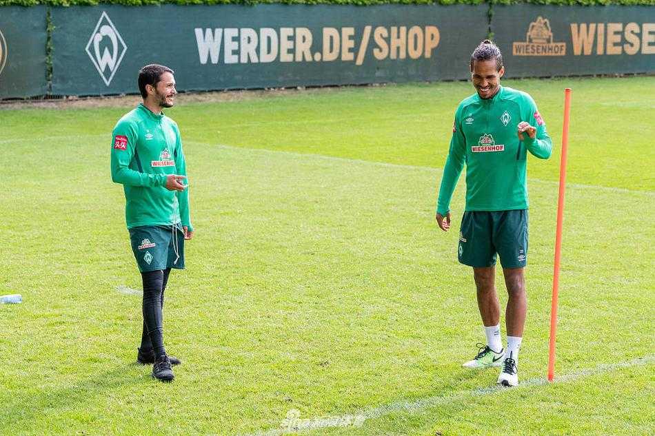 拉希察与队友在阳光下的训练场上进行抢圈热身，尽管空旷但充满活力