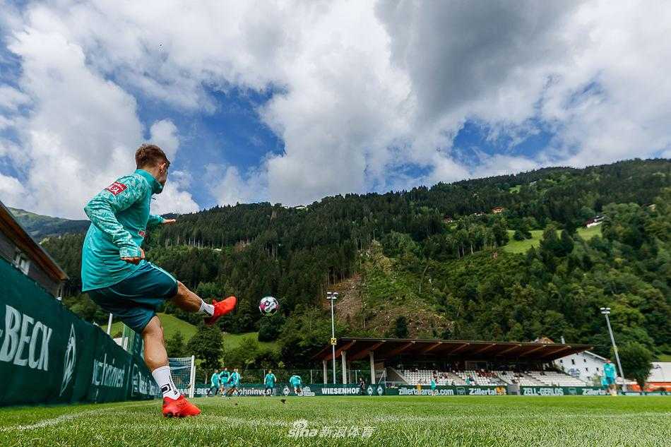 不莱梅球员在训练场上奋力冲刺，脚下的绿茵场被阳光照耀得格外鲜亮，每一寸草皮都见证着他们为新赛季储备体能的决心。