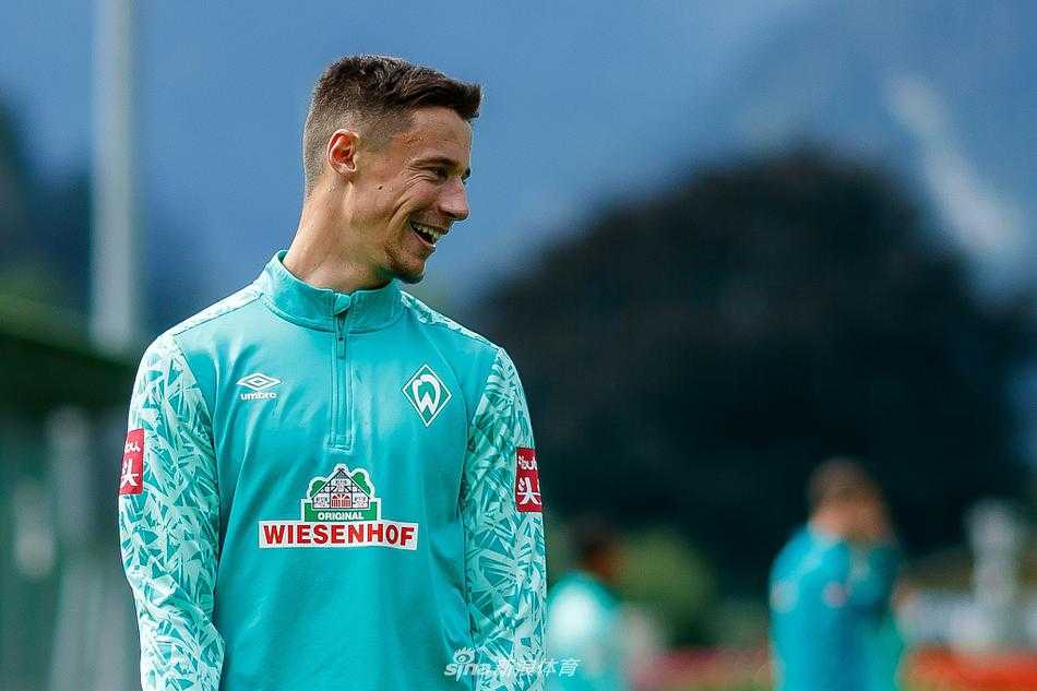 两名中场球员在一次激烈的对脚后双双倒地，但眼神依旧追逐着皮球的轨迹，展现了训练中真刀真枪的对抗强度。